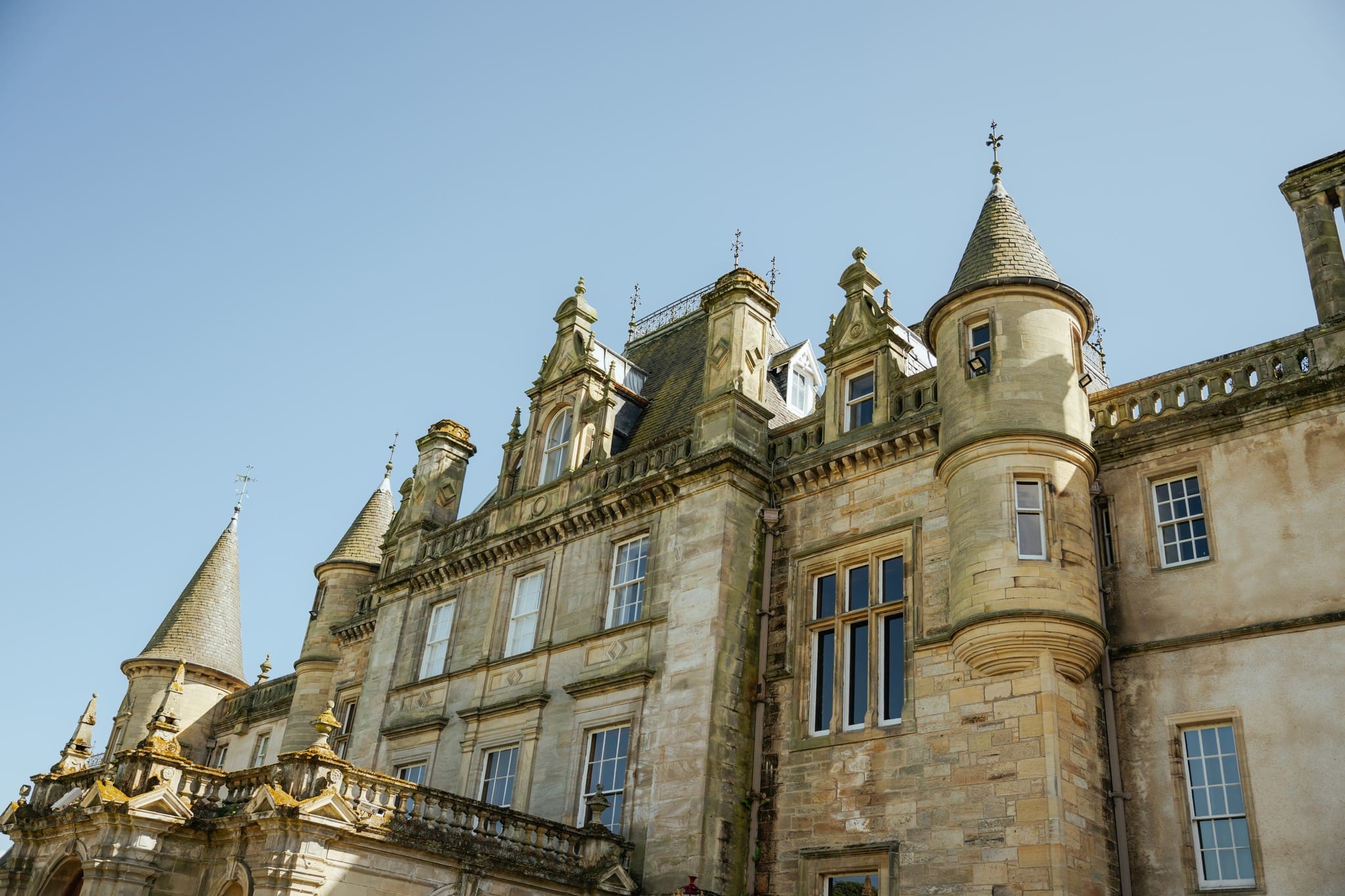 historic Scottish castle exterior with turrets and clear sky
