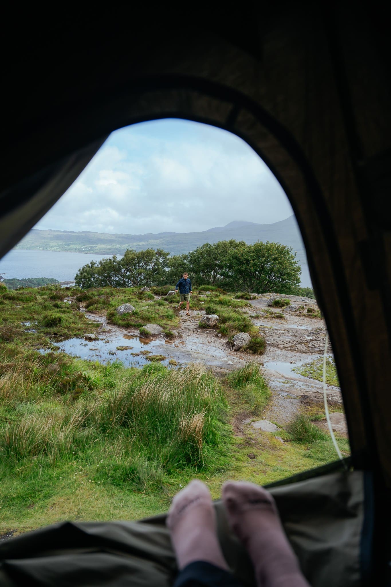 view from tent of person standing in Scottish landscape