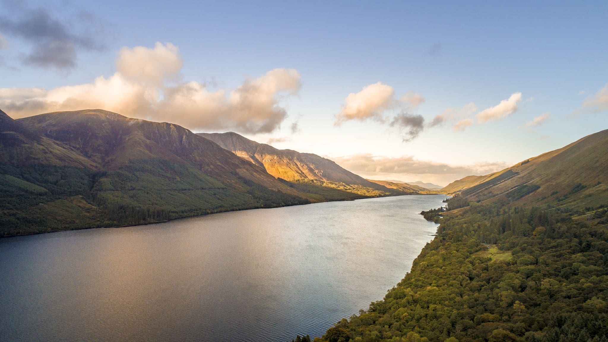 aerial view of Loch Ness lake and mountains at sunset