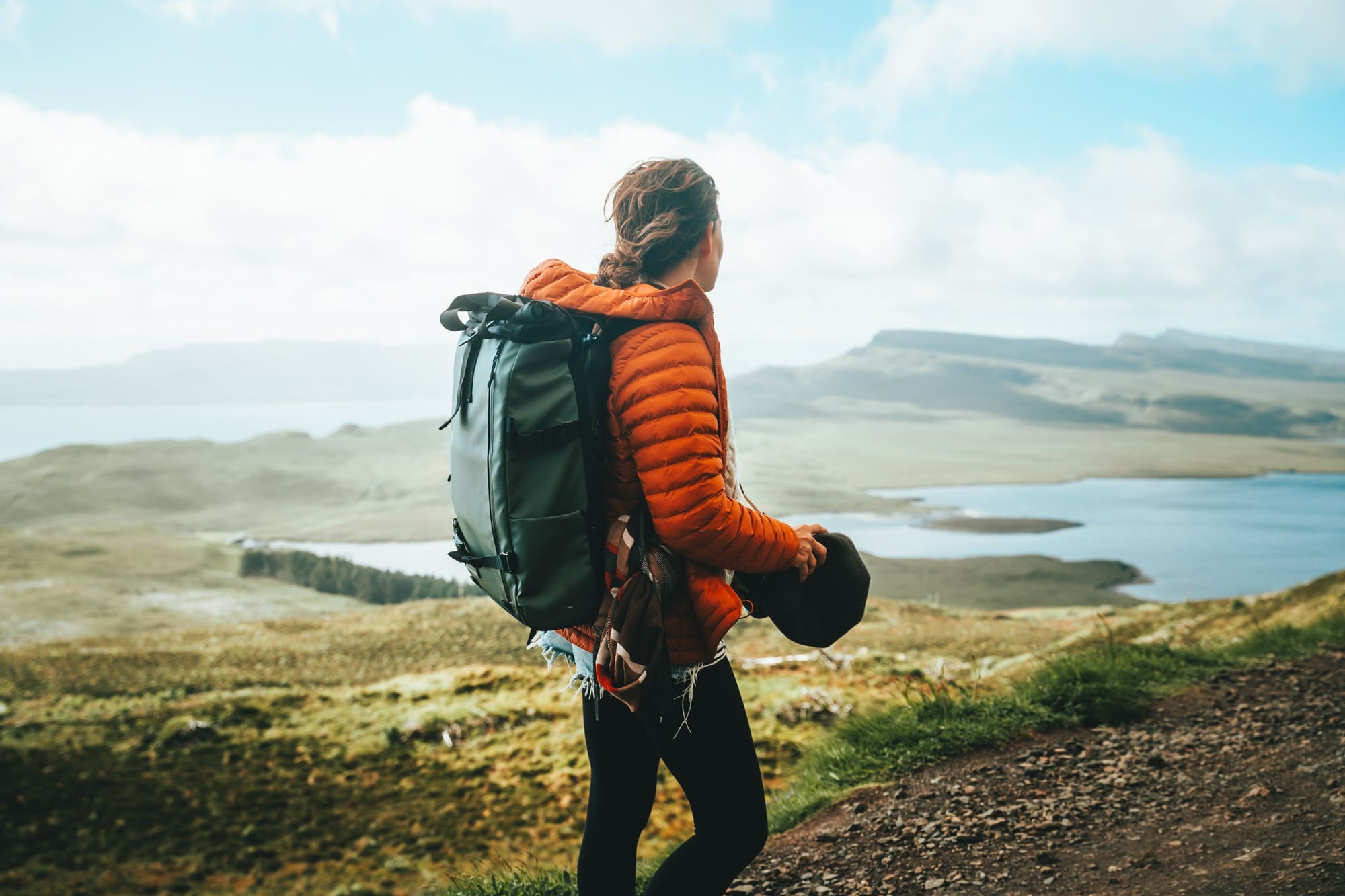hiker with backpack overlooking a vast Scottish landscape